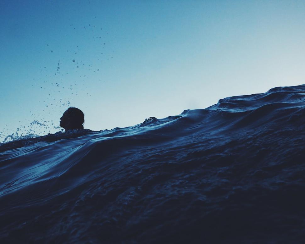 Free Image of Person Swimming in Ocean Under Blue Sky 
