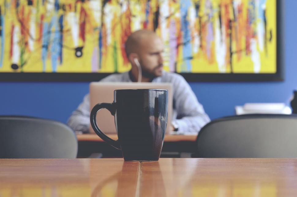 Free Image of Man Sitting at Table With Coffee Cup 