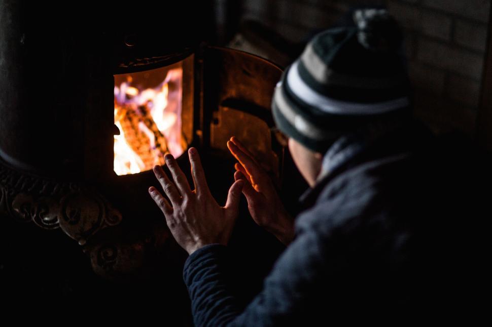 Free Image of Man Standing Next to Wood Burning Stove 