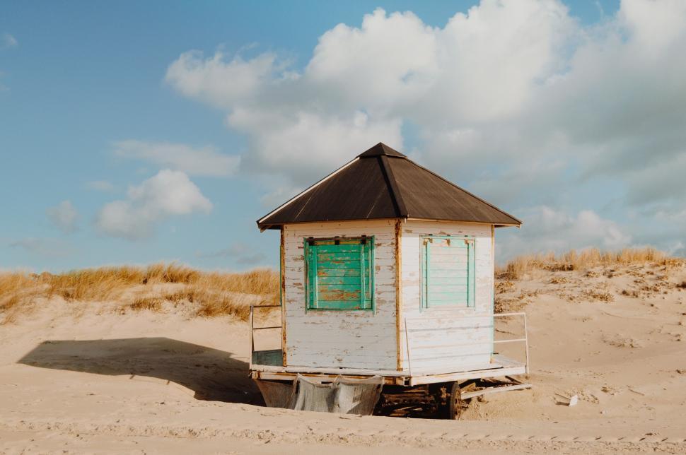 Free Image of Small White Building on Sandy Beach 
