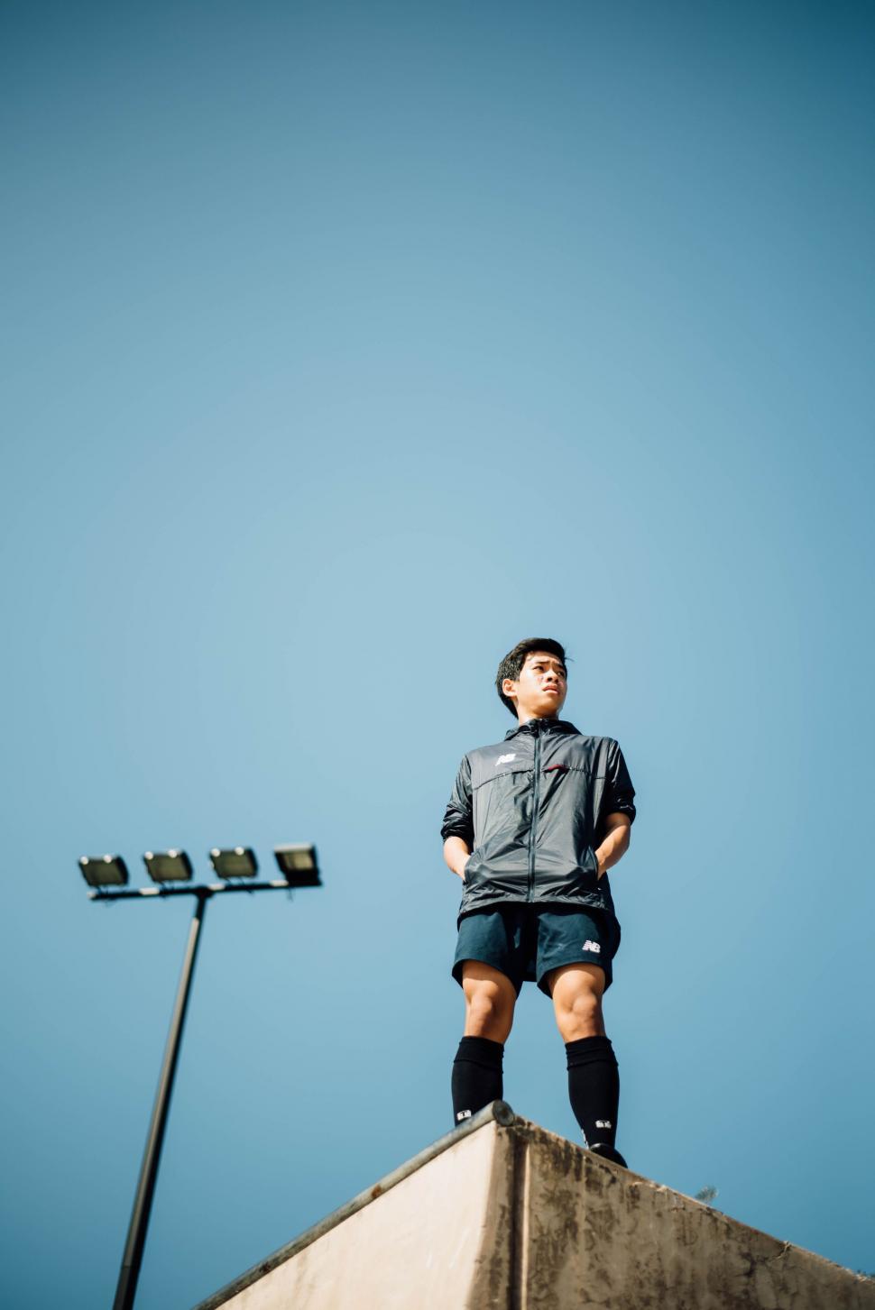 Free Image of Man Standing on Top of Cement Structure 