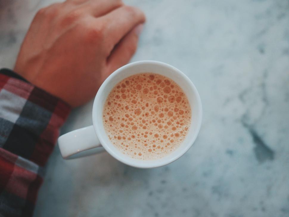 Free Image of Person Holding Cup of Coffee on Table 
