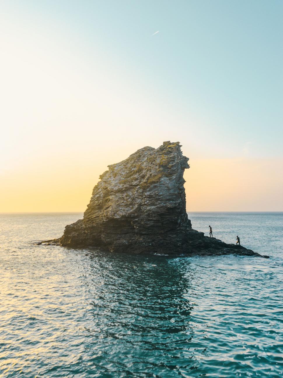 Free Image of Person Standing on Rock in Middle of Ocean 