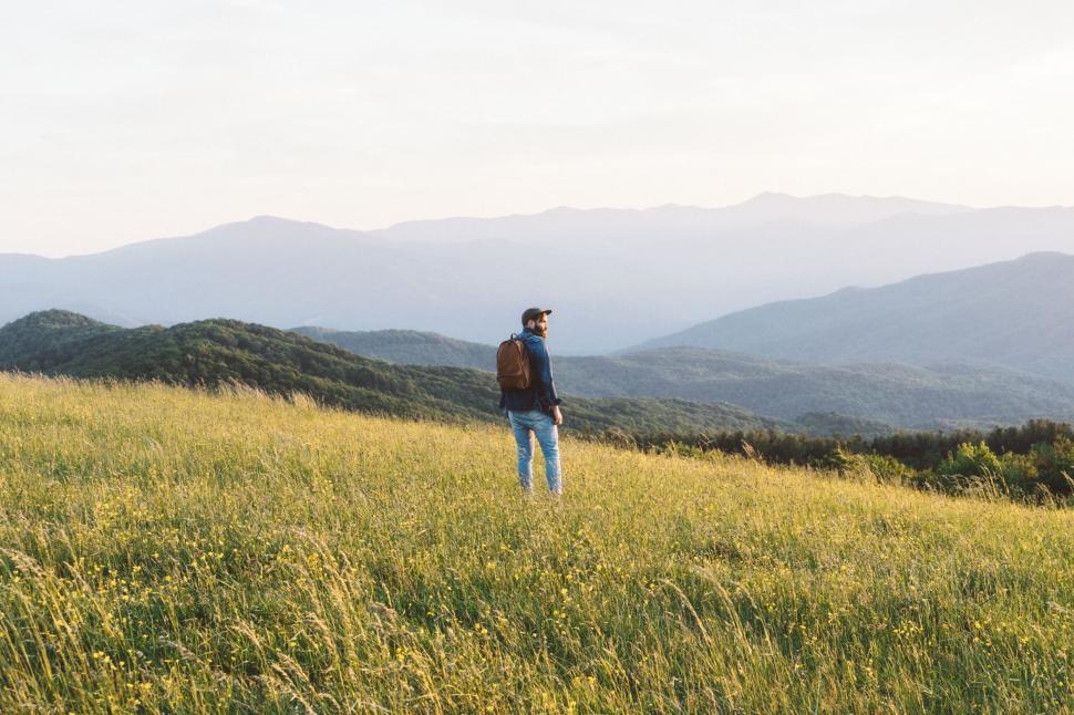 Free Image of Man Standing on Top of Lush Green Hillside 
