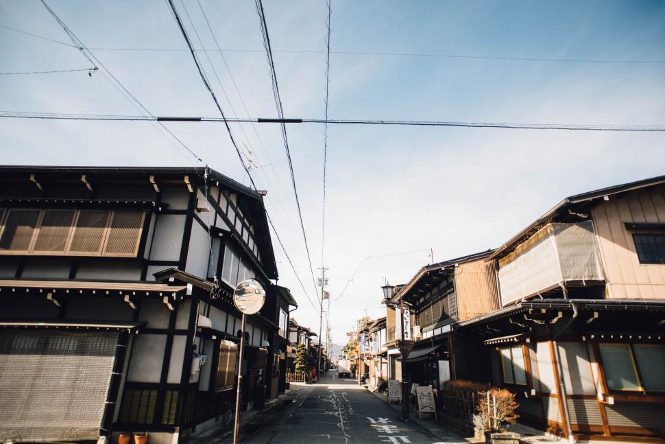 Free Image of Wooden Buildings Lining Street Under Blue Sky 