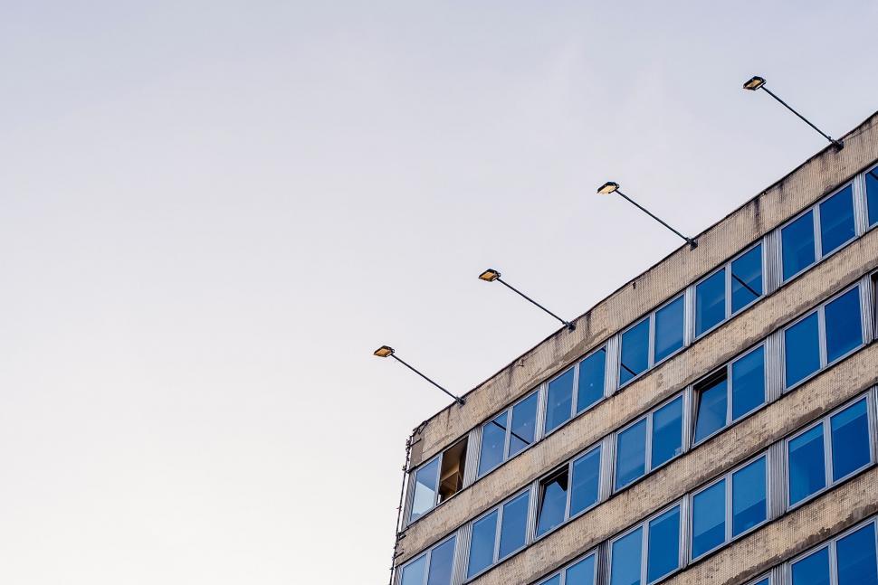 Free Image of Tall Building With Numerous Windows Next to a Street Light 