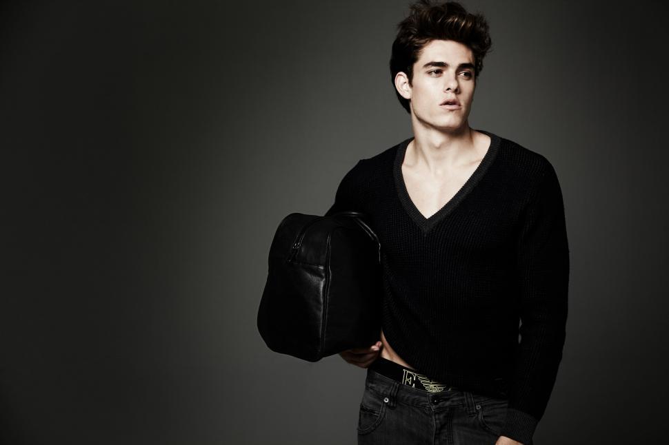 Free Image of Man in Black Shirt Holding Black Bag 