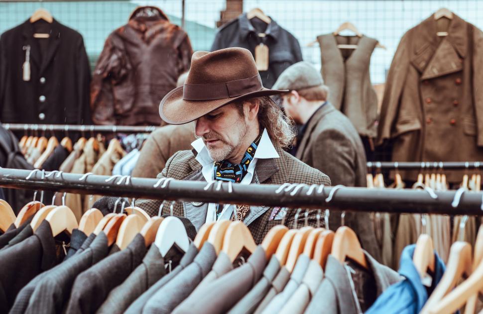 man-in-hat-standing-in-front-of-clothes-rack.jpg