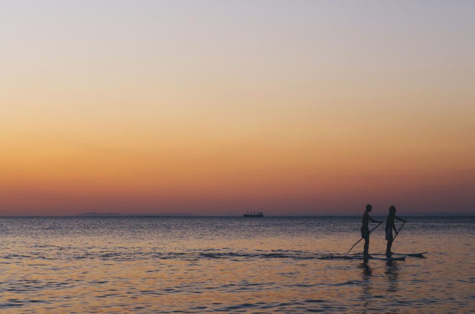 Free Image of Couple Riding Paddle Boards on Water 