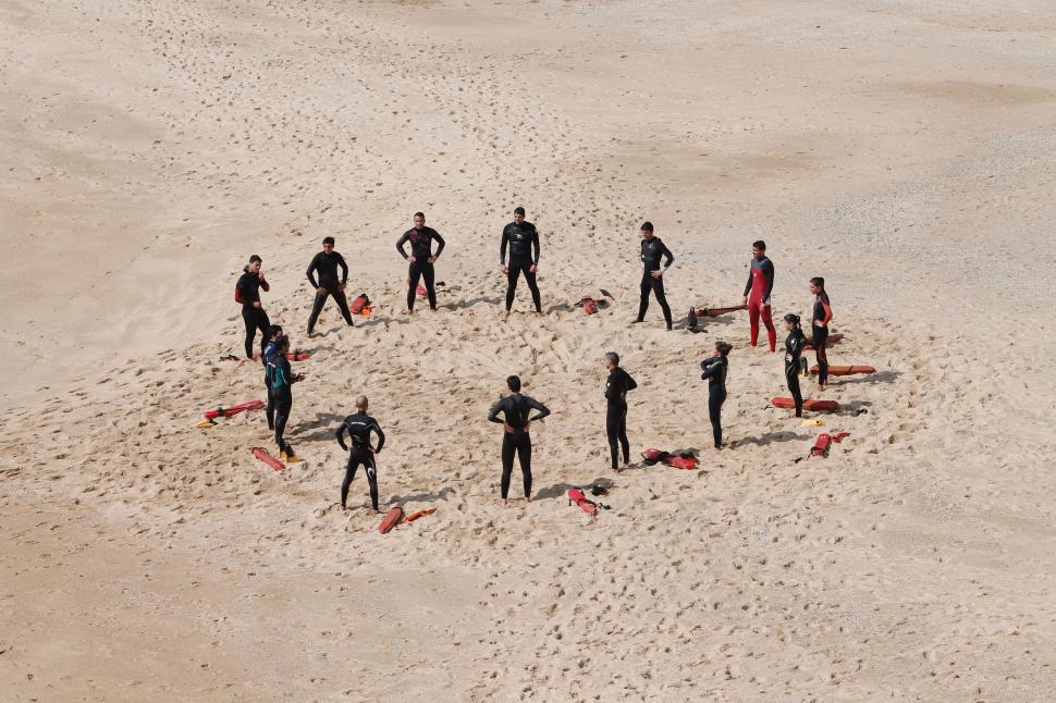 Free Image of Group of People Standing on Top of Sandy Beach 