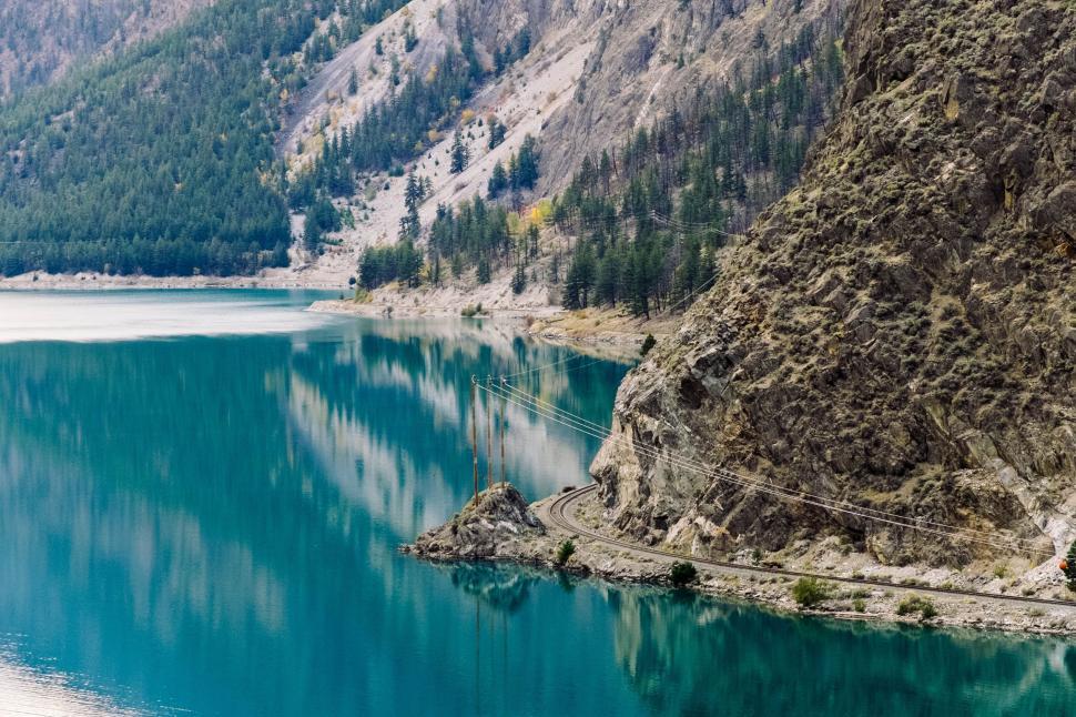 Free Image of Boat Floating on Lake Surrounded by Mountains 