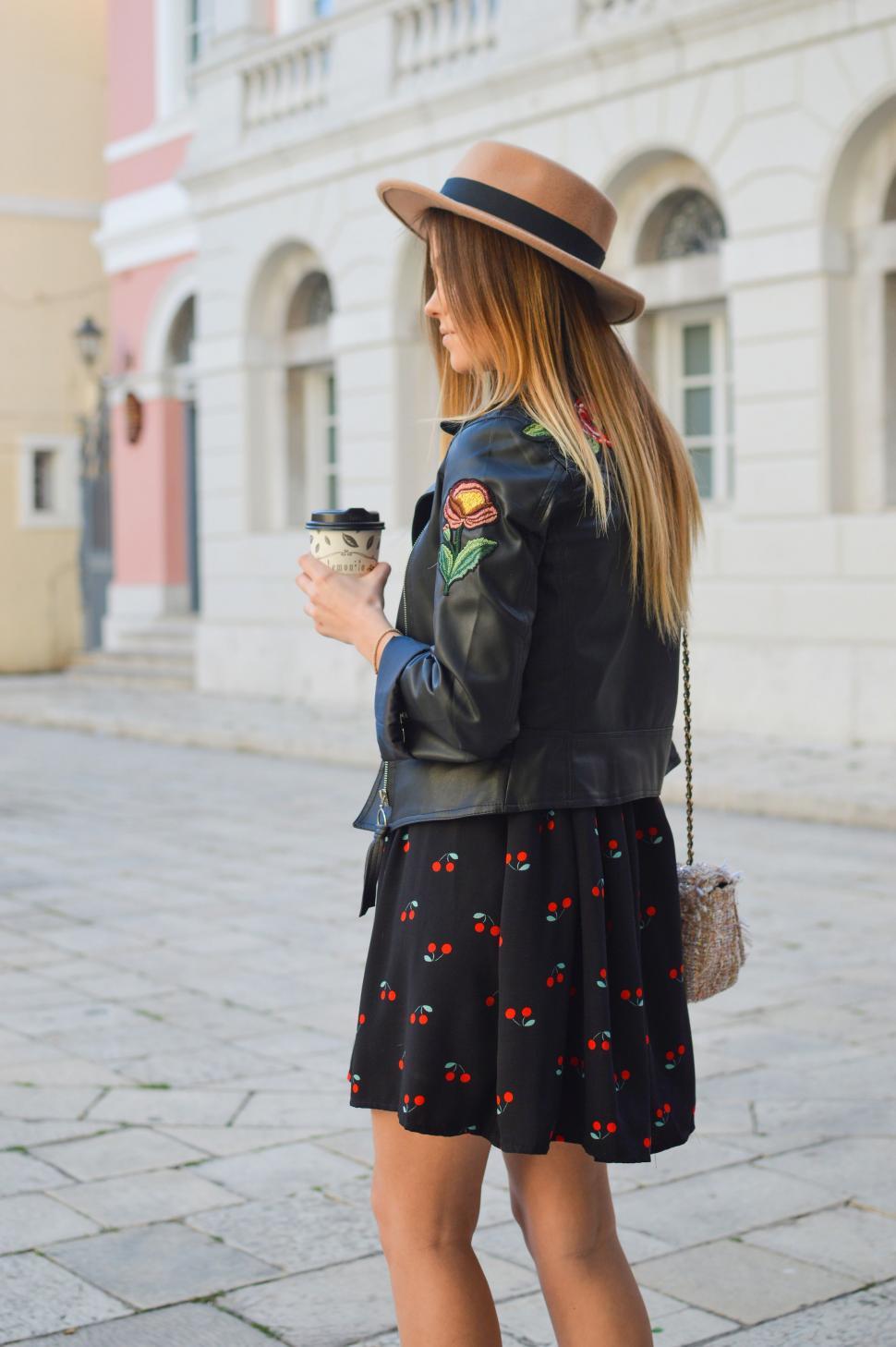 Free Image of Woman in Black Dress and Hat Holding Cup 