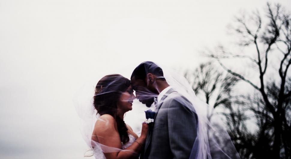 Free Image of Bride and Groom Standing in Front of a Tree 