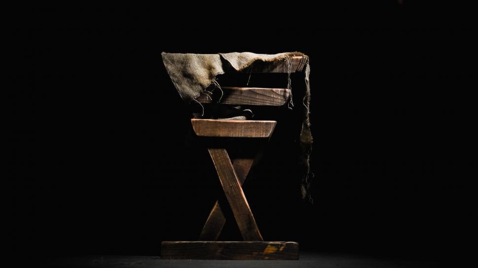 Free Image of Cat Sitting on Chair in Dark 