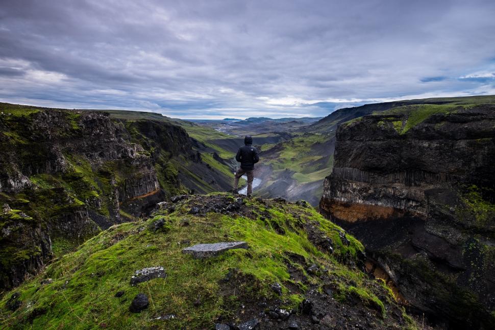 Free Image of Man Standing on Top of Lush Green Hillside 