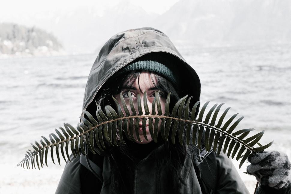 Free Image of Man Holding Plant in Front of Face 