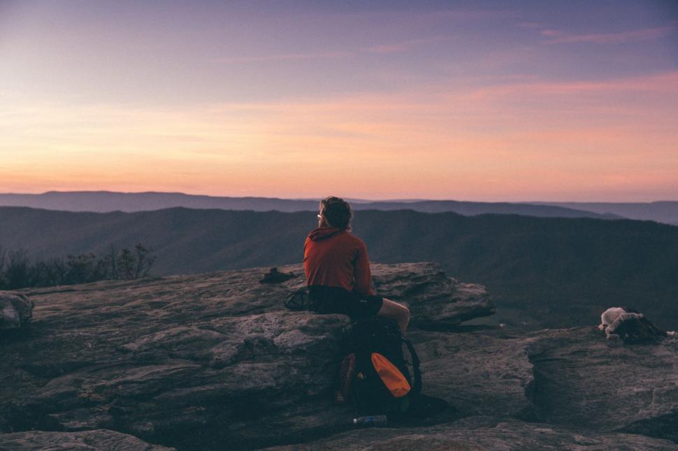 Free Image of Man Sitting on Top of a Mountain With Dog 