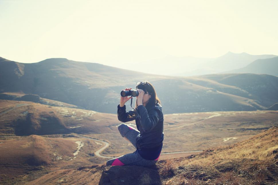 Free Image of Person Sitting on Rock Taking Picture 