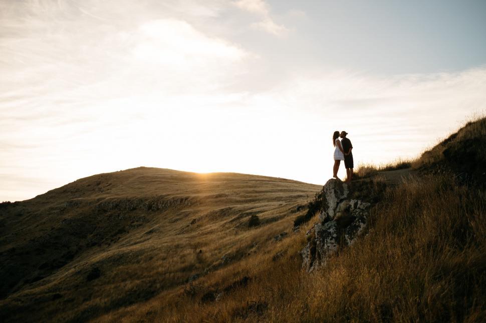 Free Image of Couple Standing on Top of a Hill 