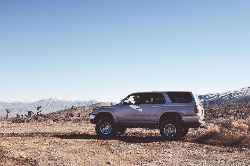 Free Image of Silver Truck Driving Down a Dirt Road 