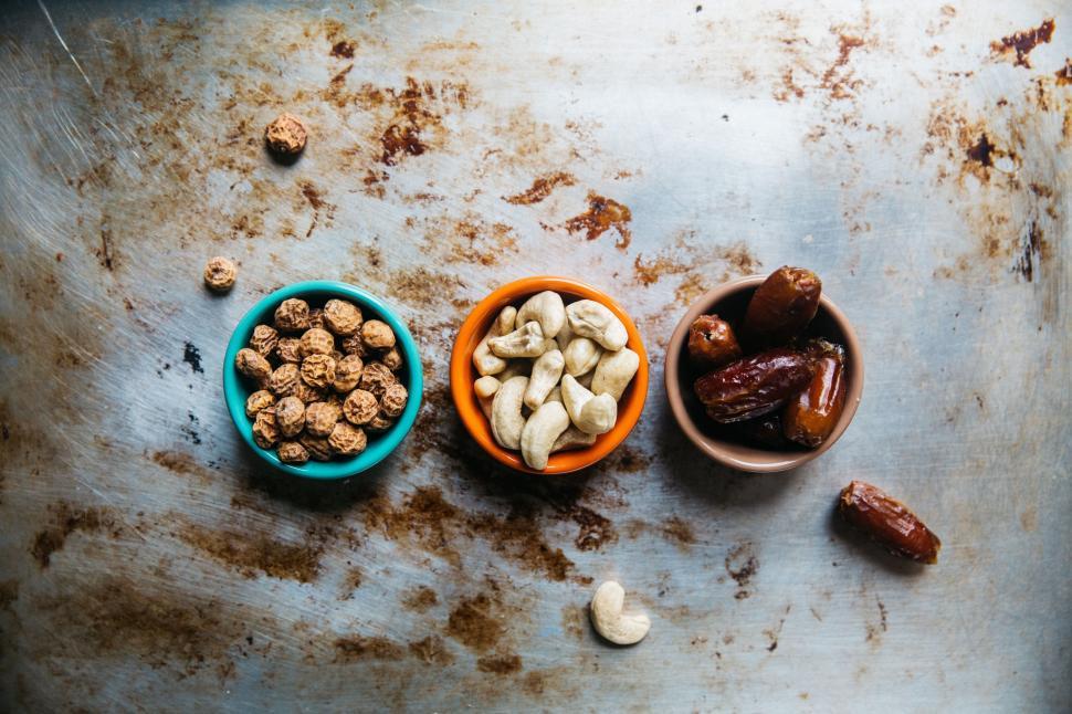 Free Image of Three Bowls Filled With Nuts on Metal Pan 