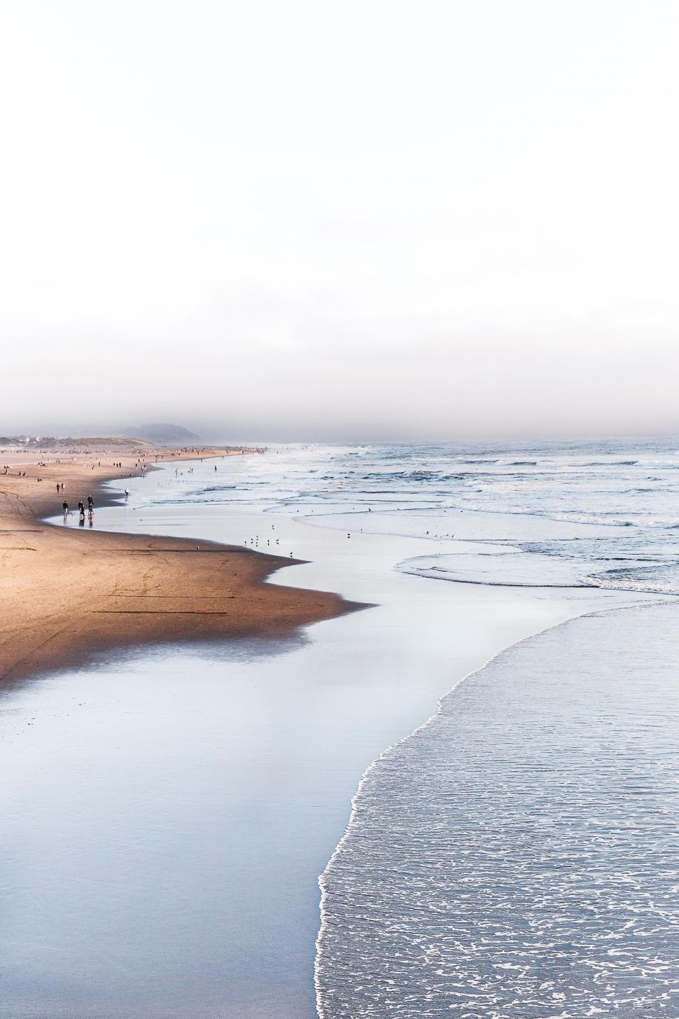 Free Image of Sandy Beach Next to Body of Water 