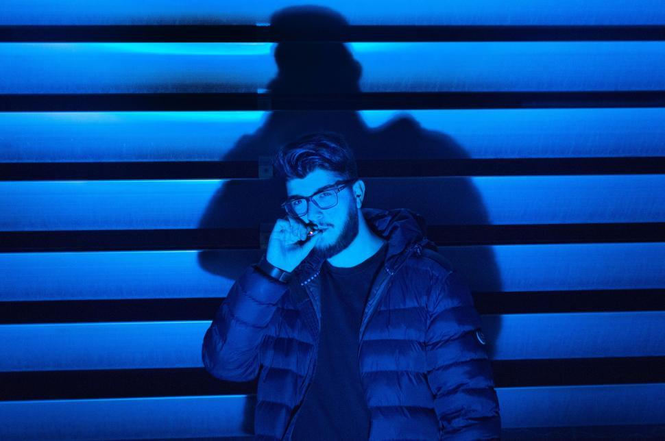 Free Image of Man Standing in Front of Blue Wall 