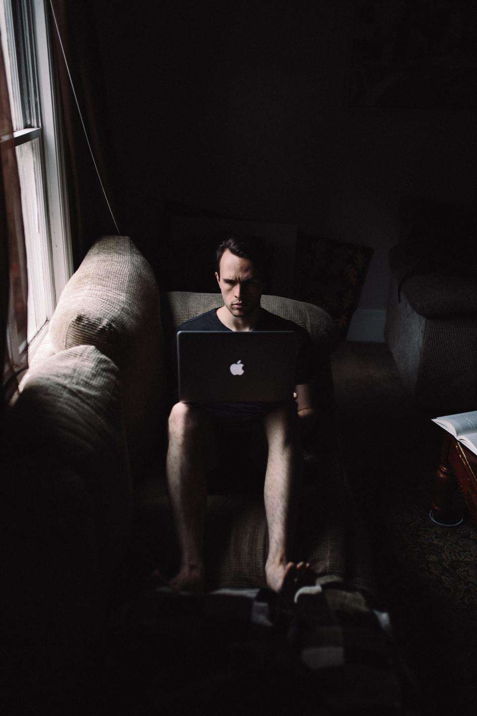 Free Image of Man Sitting on Couch Using Laptop Computer 