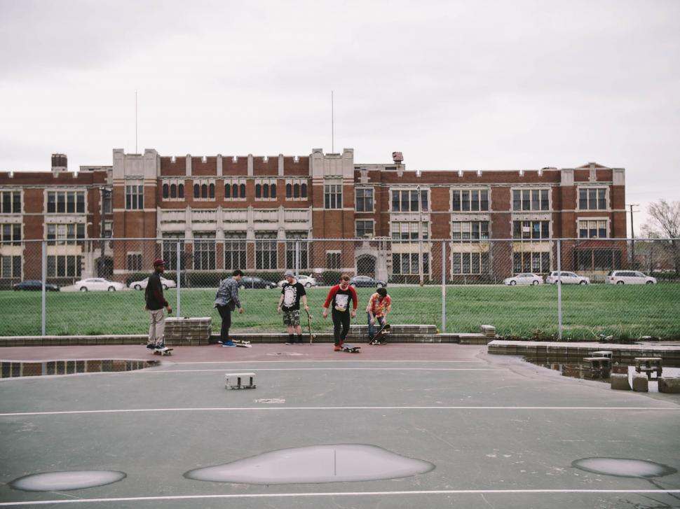 Free Image of Group of People Riding Skateboards on Top of a Parking Lot 