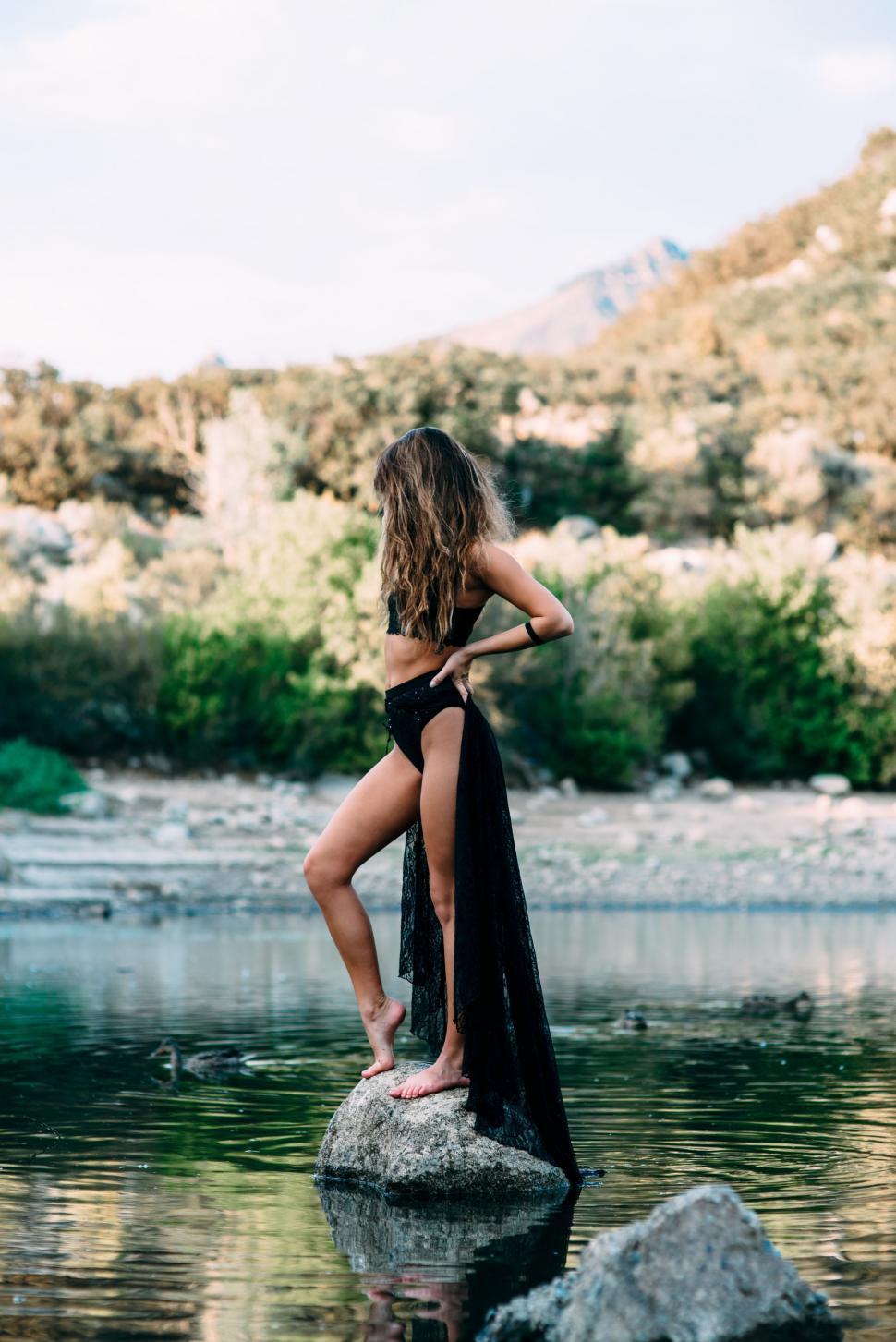 Free Image of Woman Standing on Rock in Water 