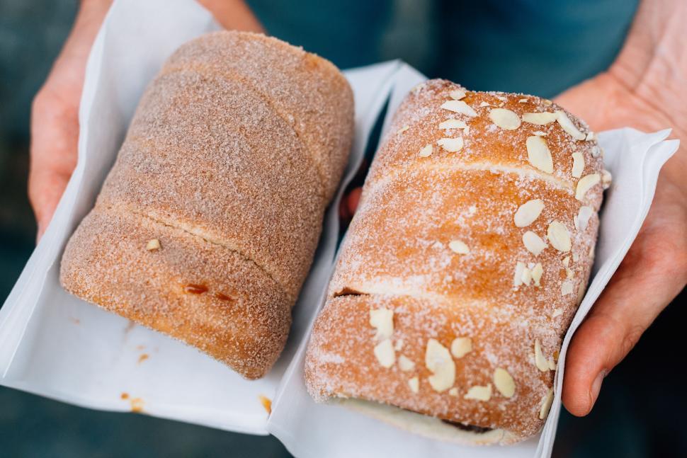 Free Image of Person Holding Two Loaves of Bread 