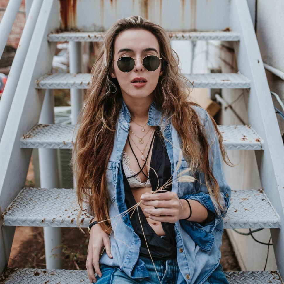 Free Image of Woman With Long Hair Sitting on a Set of Stairs 