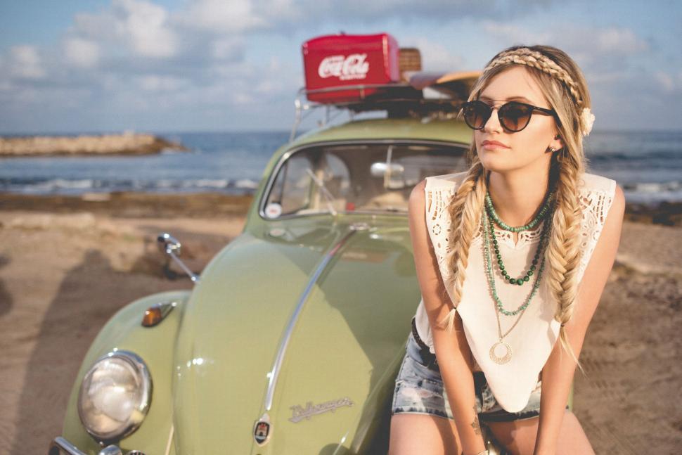 Free Image of Woman Sitting on Top of a Green Car 