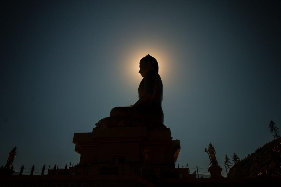 Free Image of Person Sitting on Top of Statue 