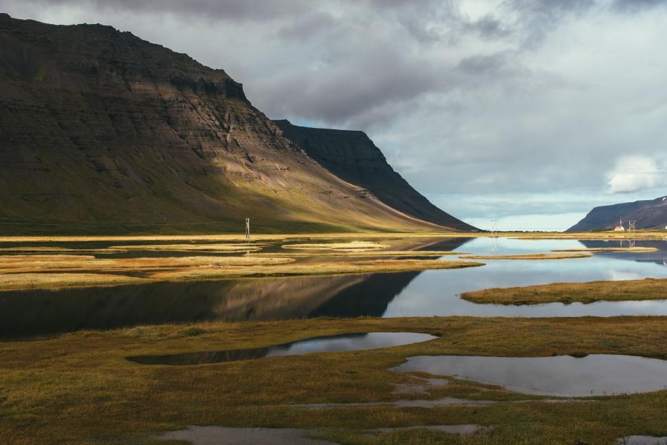 Free Image of Majestic Lake Surrounded by Mountains Under Cloudy Sky 