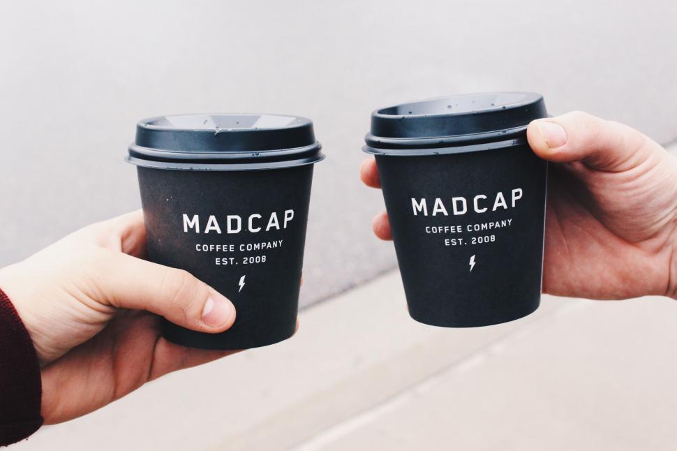 Free Image of Two People Holding Up Two Cups of Coffee 