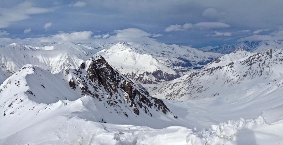 Free Image of Snow Covered Mountain Range Under Cloudy Sky 