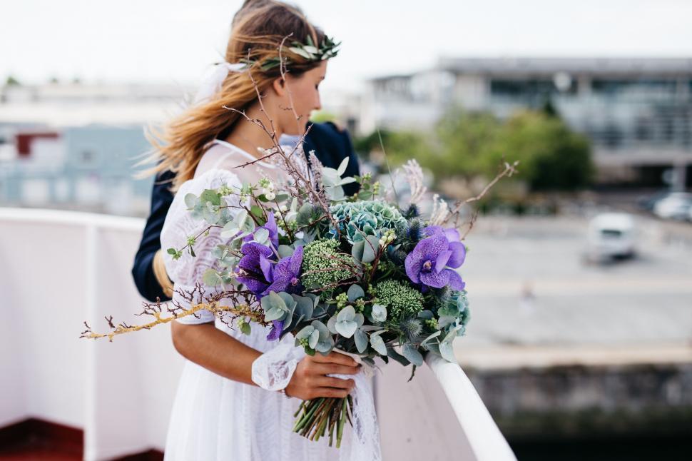 Free Image of Woman in White Dress Holding Bouquet of Flowers 