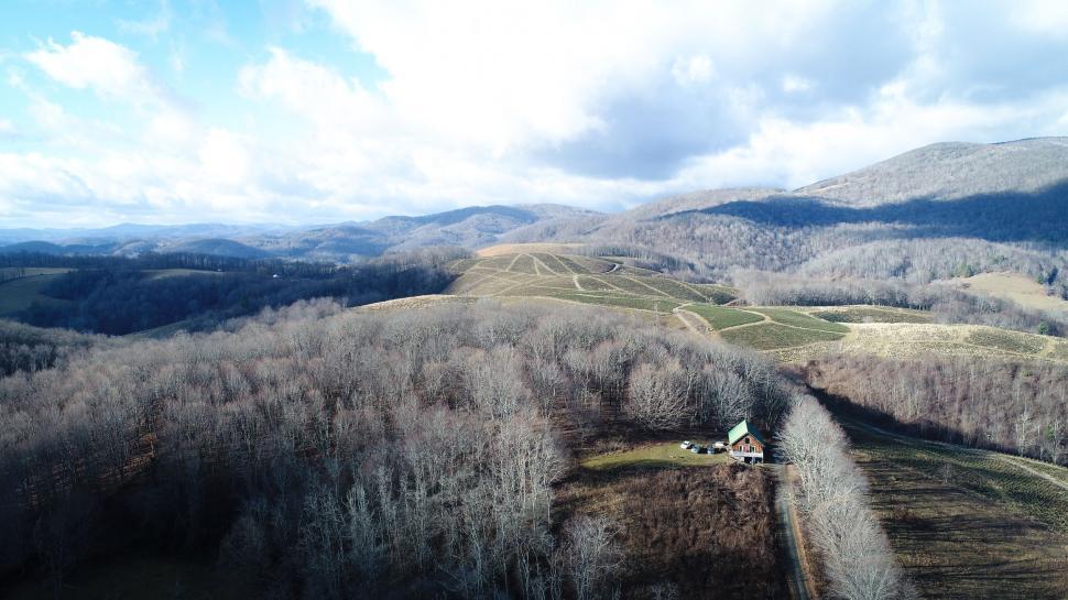 Free Image of Aerial View of Mountain Range With House in Foreground 