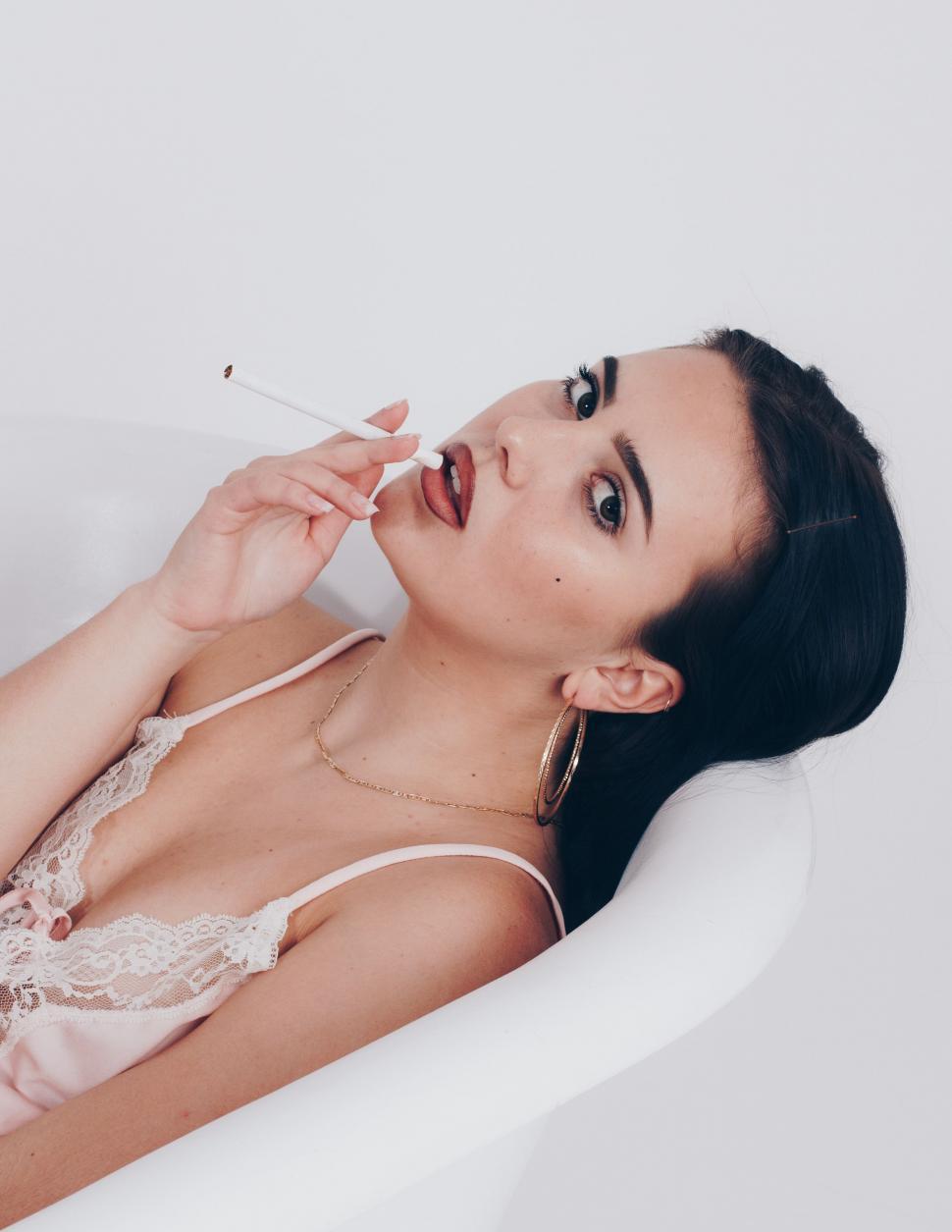 Free Image of Woman in Bathtub Brushing Teeth 