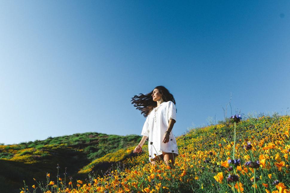 Free Image of Woman Walking Through Field of Flowers 