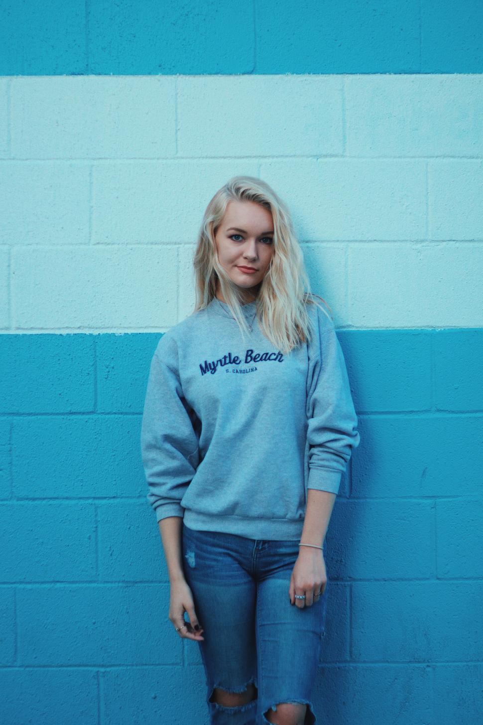 Free Image of Woman Standing in Front of Blue Wall 