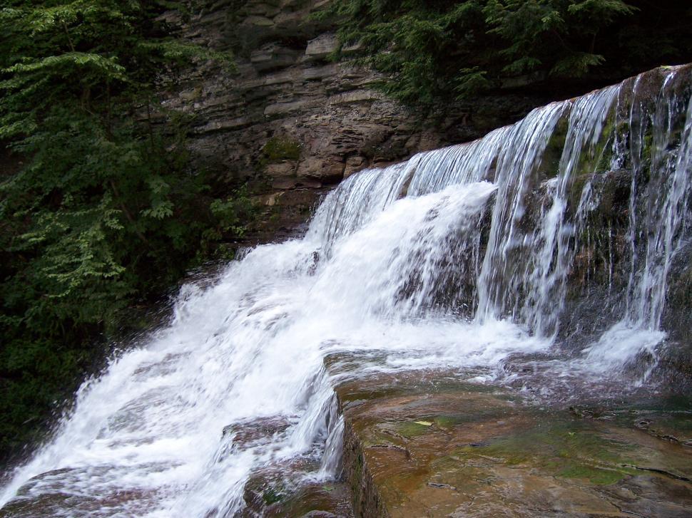 Free Image of Man Standing on Rock Next to Waterfall 