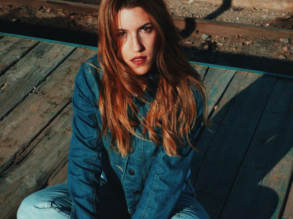 Free Image of Woman Sitting on Top of Wooden Floor 