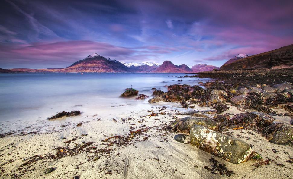 Free Image of Rocky Beach With Water and Cloudy Sky 