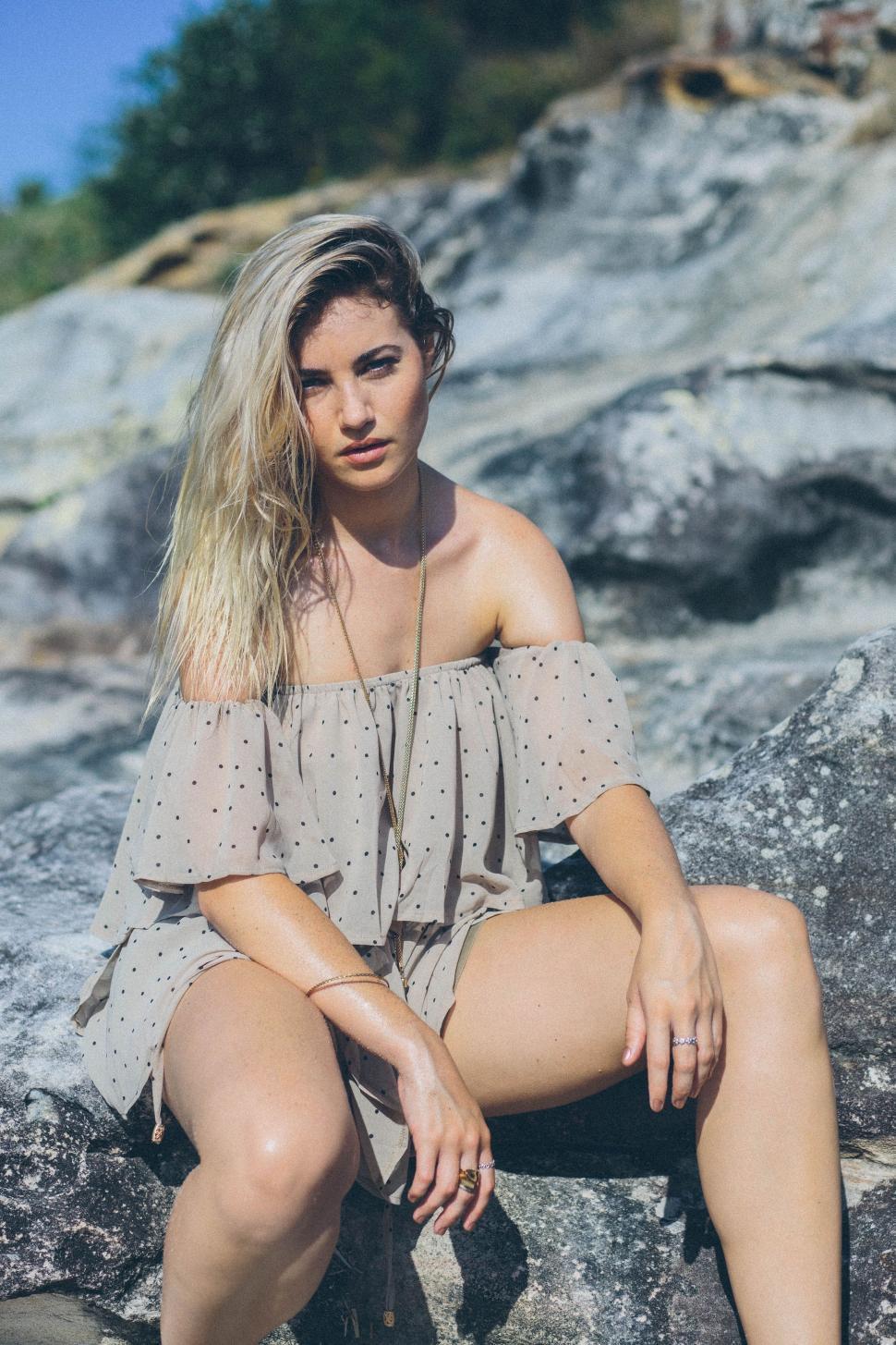 Free Image of Woman Sitting on a Rock With Legs Crossed 