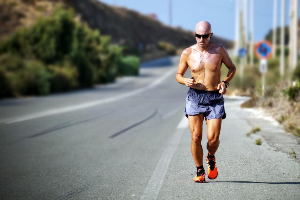 Free Image of Shirtless Man Running Down Road 