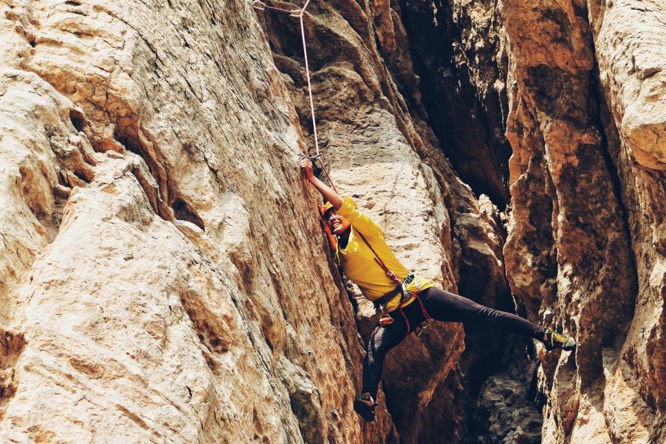 Free Image of Man Climbing Up the Side of a Mountain 