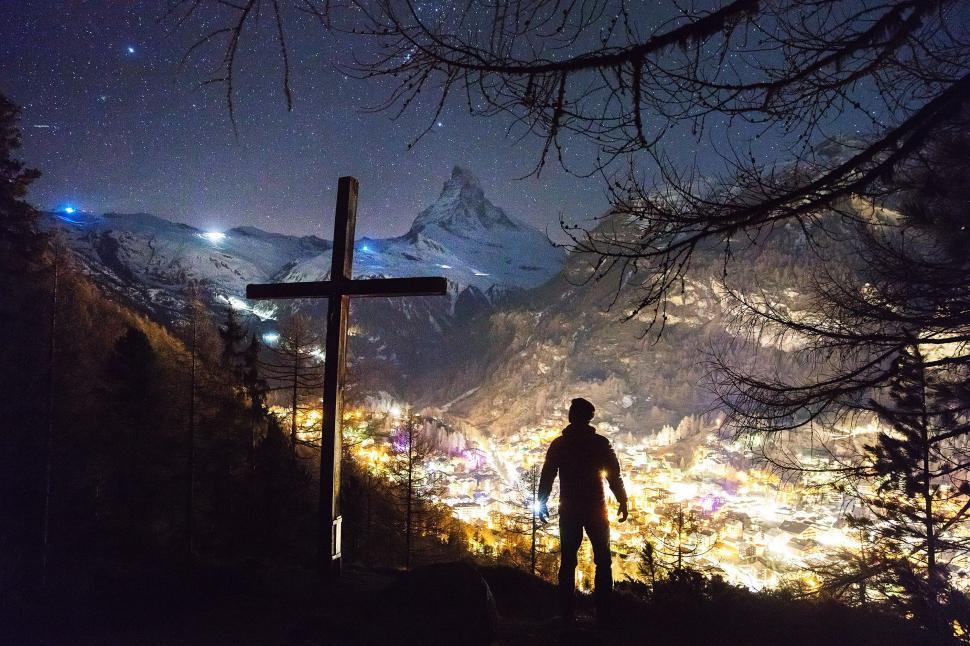 Free Image of Man Standing on Top of Hill Under Cross 