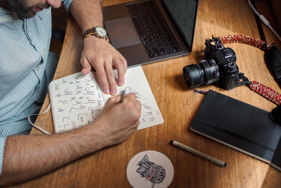 Free Image of Man Working at Table With Laptop and Camera 